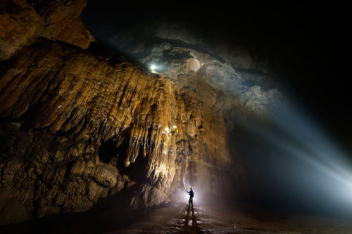 archatlas:    Hang Son Doong Carsten PeterLike a castle on a knoll, a rock formation shines beneath a skylight in Hang Son Doong. A storm had just filled the pool, signaling that exploring season was coming to an end. [via]