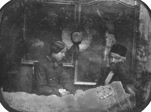 Postmortem daguerreotype portrait probably showing two parents posing with their deceased child, Eur