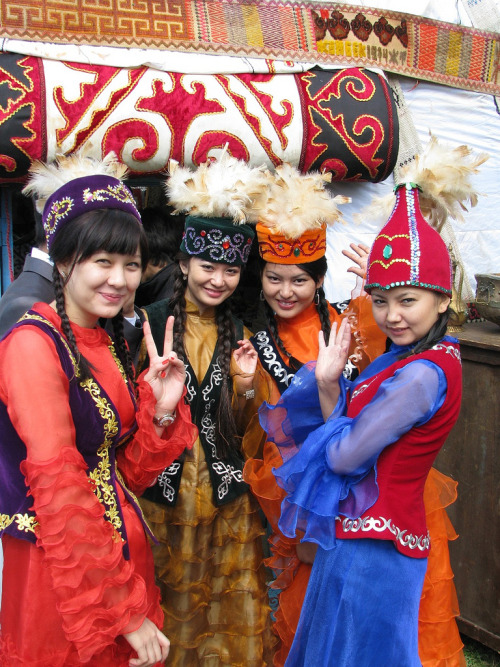 Kazakh girls helping at the Eurasia Film Festival 2011 stand near a yurt in the grounds of the Kazak