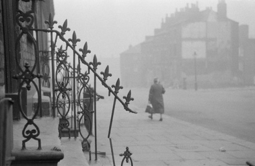 flashofgod:Thurston Hopkins, A woman out for a walk in a slum area of Liverpool, 1956.