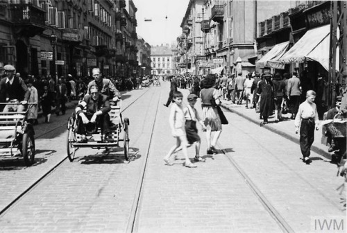 Transport in the Warsaw Ghetto in summer 1941:Street rickshaws and a tramcar carry passengers along 