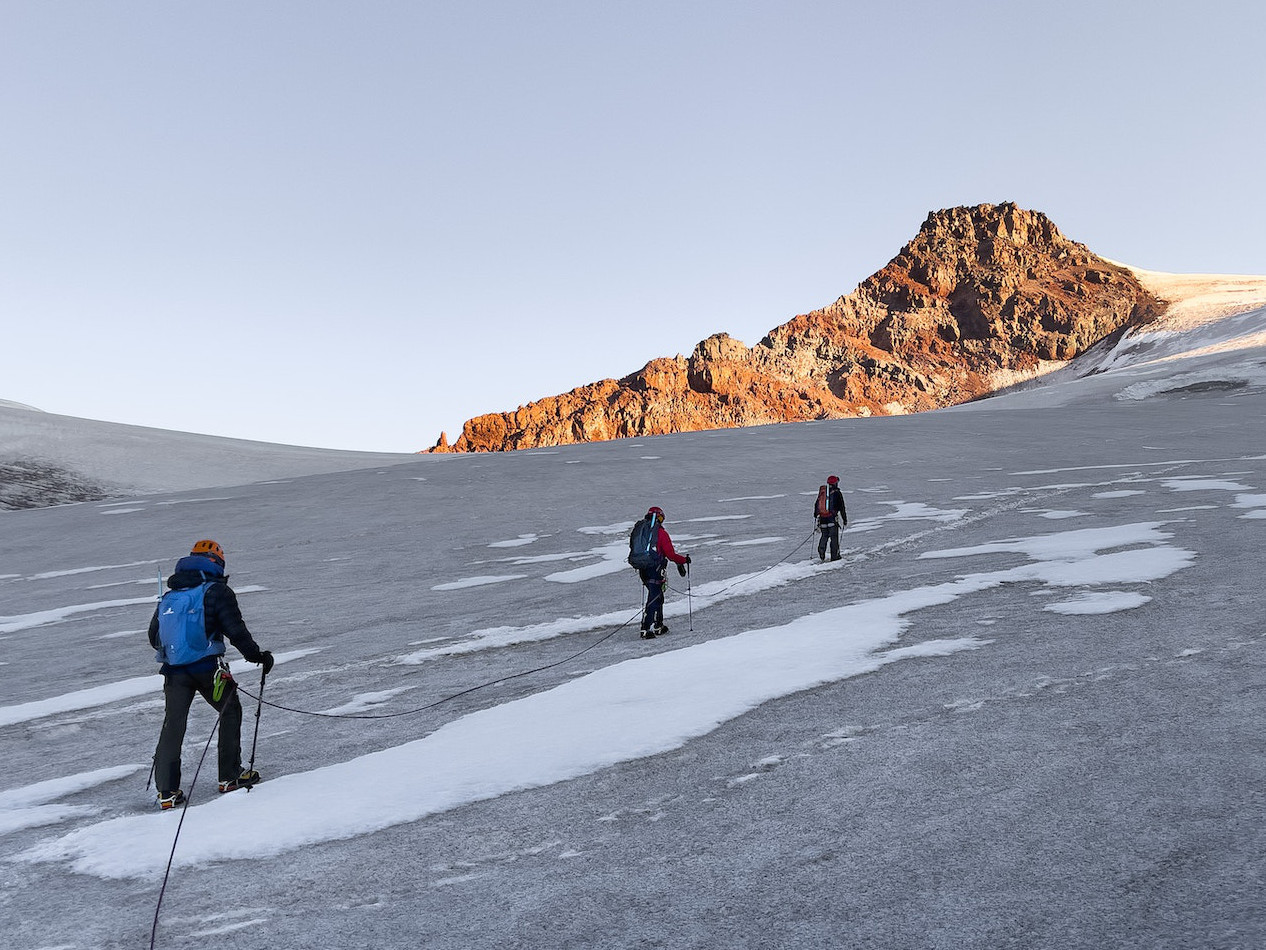 A photo by Dmitry Limonov on Pexels of three hikers walking up a snowy slope, with their backs to the camera. https://www.pexels.com/photo/people-hiking-during-winter-9101711/