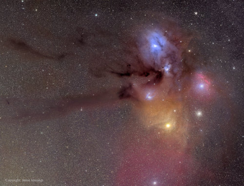 Explanation: Connecting the Pipe Nebula to the colorful region near bright star Antares is a dark cl