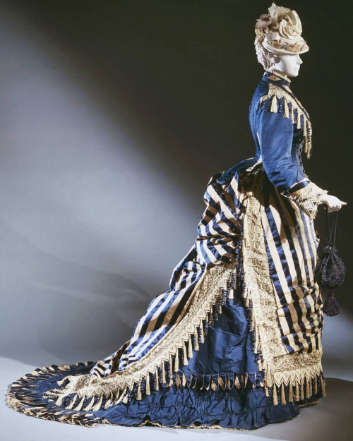 1874 reception dress by Emile Pingat. Silk with stripes of dark blue satin and tan plain weave; dark