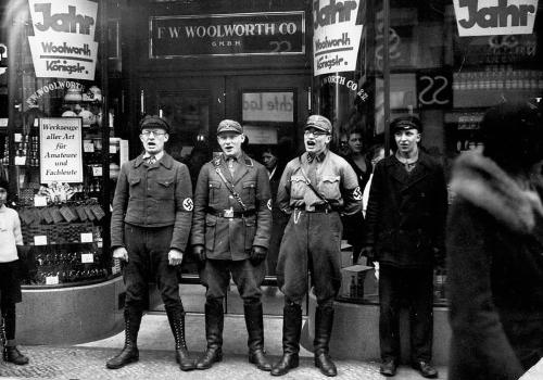 Nazitroops sing in front of the Berlin branch of the F. W. WoolworthCompany to encourage a boycott o