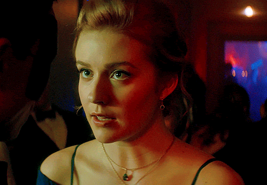 GIF FROM EPISODE 1X06 OF NANCY DREW. CLOSE-UP OF NANCY AT THE VELVET MASQUE PARTY. THERE ARE PARTY-GOERS IN THE BACKGROUND. SHE'S LOOKING AT NICK WHO IS PARTIALLY IN FRAME. NANCY CLOSES HER EYES ON A DEEP SIGH.