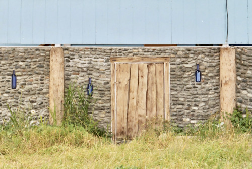 Stone Wall With Wooden Door and Blue Bottles, Alert Bay, British Columbia, 2003.