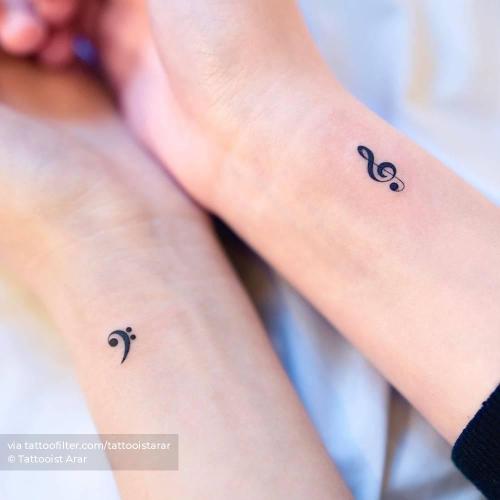 Individual matching bass and treble clef tattoos