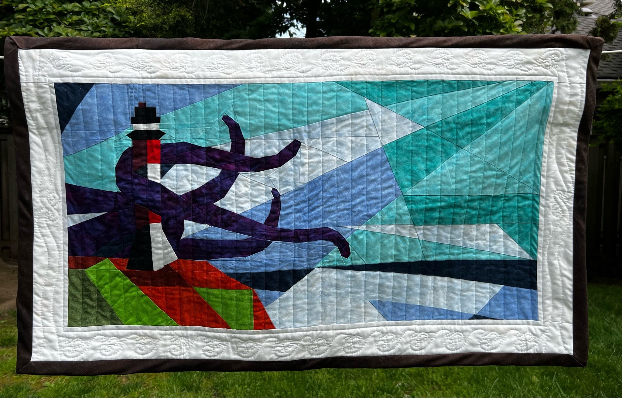 a quilted version of the lighthouse painting from Our Flag Means Death, with tentacles wrappped around the lighthouse reaching outward. 