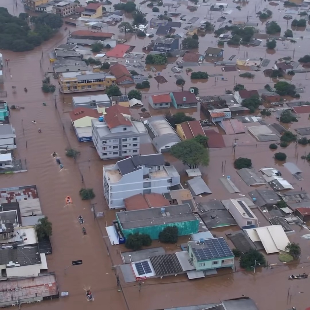 Picture taken in Canoas. An aerial view of a neighborhood partially submerged in water. Twelve boats are navigating in search of stranded and missing people.