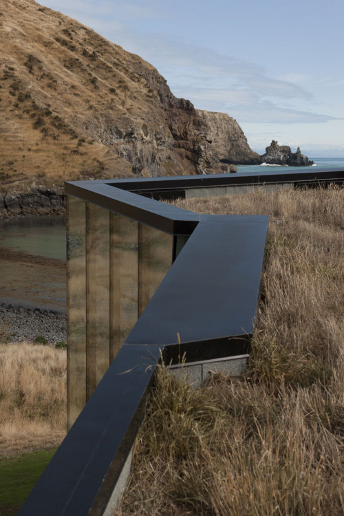 archatlas:    Seascape Retreat    Patterson AssociatesA romantic beachside cottage is set into a rock escarpment in a tiny boulder strewn South Pacific cove. It is a shelter designed as a honeymoon retreat for paying guests consisting of just three rooms,