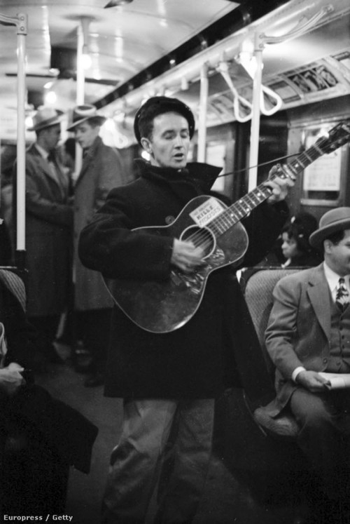 newyorkthegoldenage:Woody Guthrie serenading New Yorkers on a subway train, 1943. The sign on his gu
