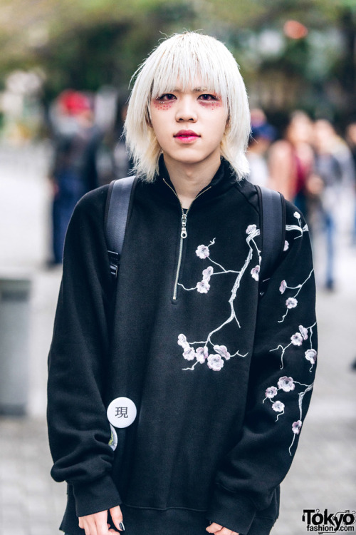 20-year-old Japanese fashion student Min on the street in Tokyo. He is wearing glitter makeup, a flo