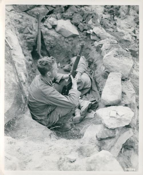 Pvt. Jim Sullivan (Modesta, Ca) of the 19th infantry Regiment, 24th infantry Division, watching for the enemy while his buddy gets a little rest, near Chinju/31 Jul 1950