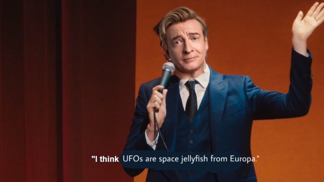 an edited screenshot of john mulaney saying "I think Emily Dickinson is a lesbian!" rhys darby's head has been edited over john's. the text has been changed to read "I think UFOs are space jellyfish from Europa."