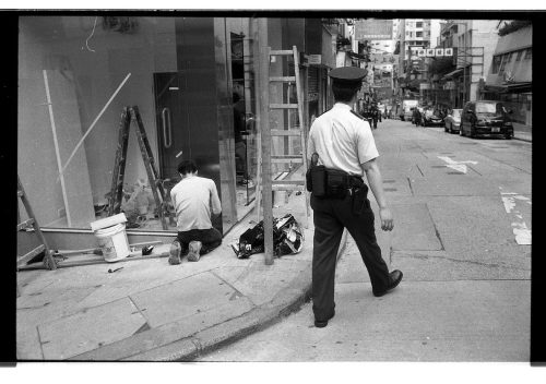 The police and the laborer at the corner in Mong Kok, Hong Kong