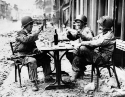 semioticapocalypse:  In fallen La Haye du Puits, France, Robert McCurty, left, Sgt. Harold Smith and Sgt. Richard Bennett, raise their glasses in a toast. July 15, 1944.   [::SemAp FB || SemAp G+::]