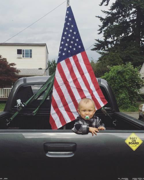 daddy took a picture with little man in the back of his pickup truck with his flag for Memorial Day 