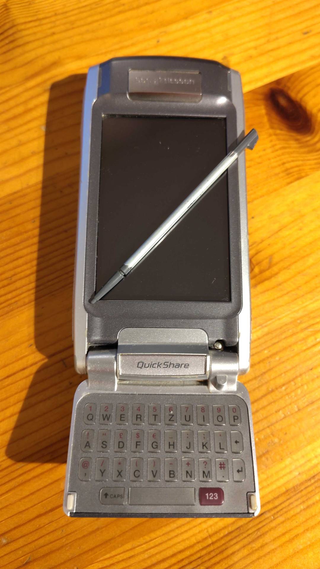 Ein Soy Ericsson P910i mit ausgeklappter Tastatur und Stift für das Touchpad.