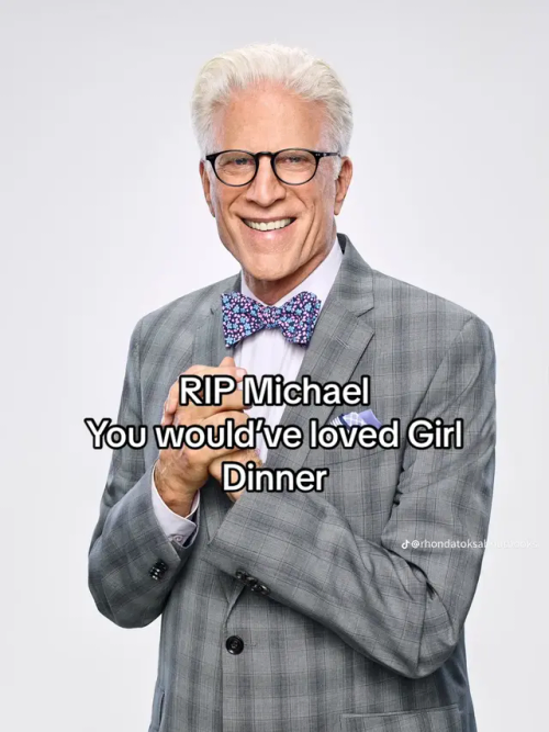 A picture of Michael smiling connivingly, with his hands in front of him that looks like he is trying to concoct a plan into action. He is wearing glasses, a gray suit, and a bowtie with blue flowers and pink leaves. There is text over the image that reads: "RIP Michael You would've loved Girl Dinner"