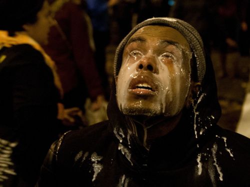 berlin1991:unrar:A protester pours milk in his eyes after being tear gassed by Seattle police at the