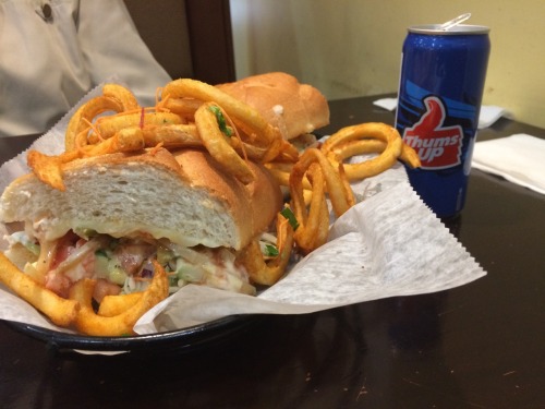 Mitaas special sub under a pile of curly fries. Thums Up to wash it down. Just wait, Indian hoagies are coming.