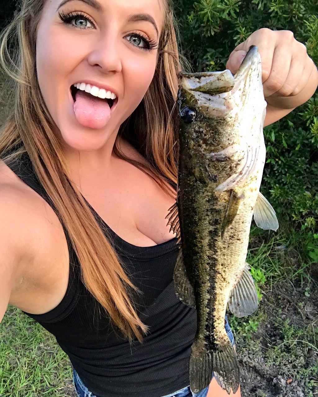 girl bass fishing on boat