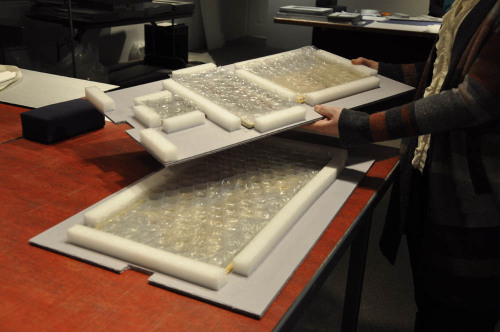 Chief Conservator Esther Méthé is working on packing our small collection of textile fragments that 