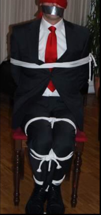 rennegade15:  tied up Businessman in a dark grey suit + white shirt + red tie + white ropes 