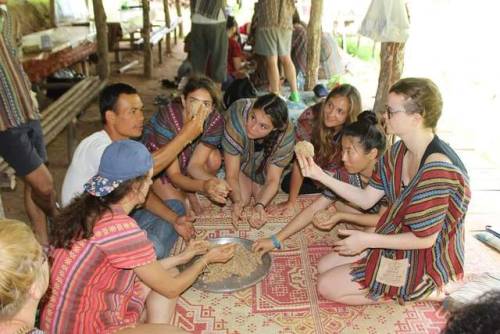 Mixing the banana bash with grain and bark for elephant digestion.