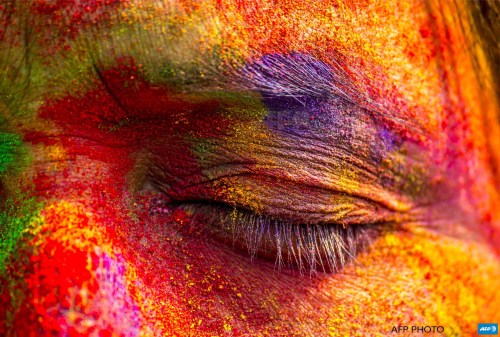 afp-photo:INDIA, SIVASAGAR : An Indian woman’s face is smeared with colored powder during celebrations of the Holi festival in the Sivasagar district of  northeastern Assam state on March 6, 2015.  Holi, the festival of  colours, is a riotous celebration