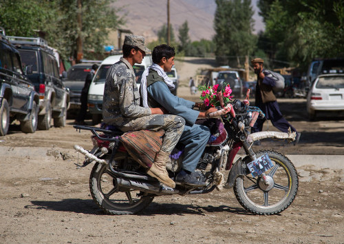 Men riding a motorcycle in the streets of the market, Badakhshan province, Ishkashim, Afghanistan. T