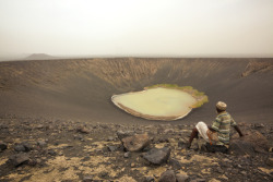 unrar:  An Afari guide rests at the Catherine Ash Ring volcano, Ethiopia, George Steinmetz.