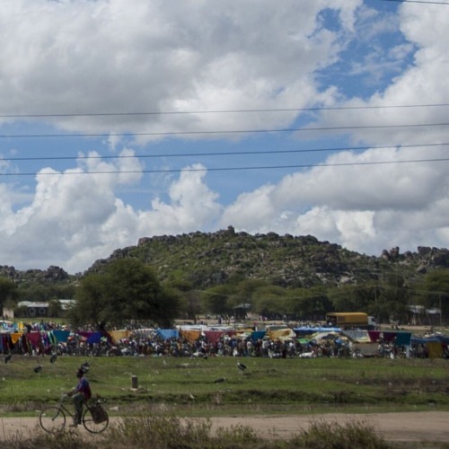 A Cyclist Rolls Past A Market In Mwanza, Tanzania. #mwanza #tanzania #africa #bicycle #cyclist #market