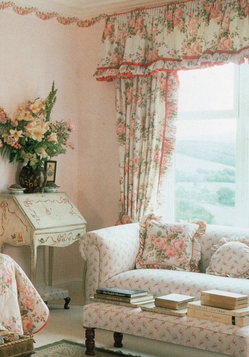 A deeply romantic bedroom in a soft shade of pink, centering on a glorious bed of roses. The heady t