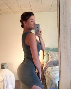 Showing off her ass in a gray dress