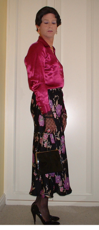 A lovely silky mauve blouse with black floral patterned skirt and patent stiletto and handbag.