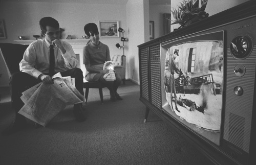 A man and a woman sit in their living room, watching film footage of the Vietnam War on TV.Learn mor