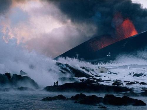 Lava creeping over a house in Vestmannaeyjar, Iceland&rsquo;s mostimportant fishing port, during the