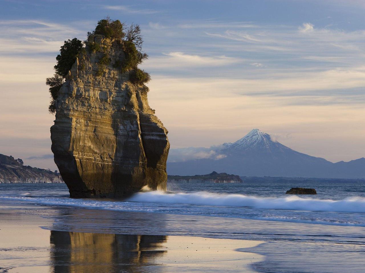 theencompassingworld:  Sea Stack and Mount Taranaki, New ZealandMore incredible scenic