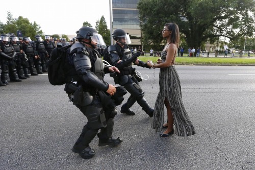 pleasetrysomethingelse:  e4knee:  frontpagewoman:  This picture is breaking Twitter: Woman confronts police at BLM protest in Baton Rouge, Louisiana. Who is she?✊🏾   This picture is so striking. She is like an ancient statue brought to life to defend
