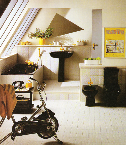 80sdeco: penthouse bathroom with black porcelain with yellow fixtures, exercise bike, acute triangle