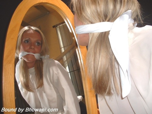 graybandanna:  Lucy Zara gags herself in the mirror with a white scarf before being tied to a chair, gagged with another scarf and blindfolded 
