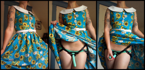 strap-onwomen: Interesting study in contrasts. Sleeve tattoos, 50s style housewife dress, and a strapon. I like it - I like it a lot.