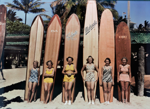 Women pose in front of their surfboards on Waikiki beach in Honolulu, November 1938.Photograph by Ri