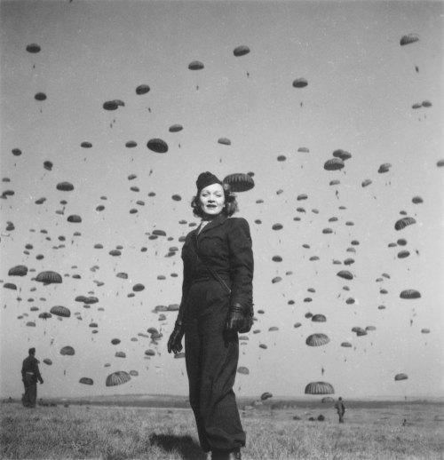 wehadfacesthen:Marlene Dietrich in Germany, 1945, as American paratroopers descend from the sky. Die