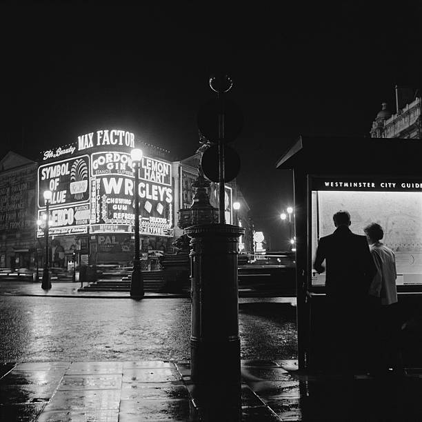 undr: Harry Kerr. Tourists read a map at Piccadilly Circus, near the statue of Eros.