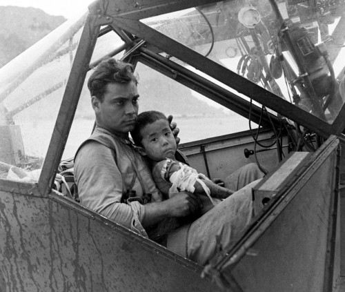 historicaltimes:An American soldier cradles a wounded Japanese boy and shelters him from the rain in