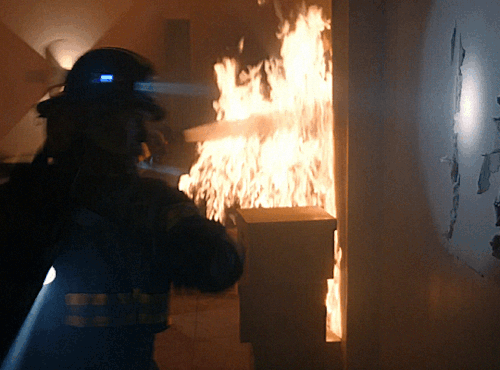 Bobby trying to break through the wall to rescue May from a fire
