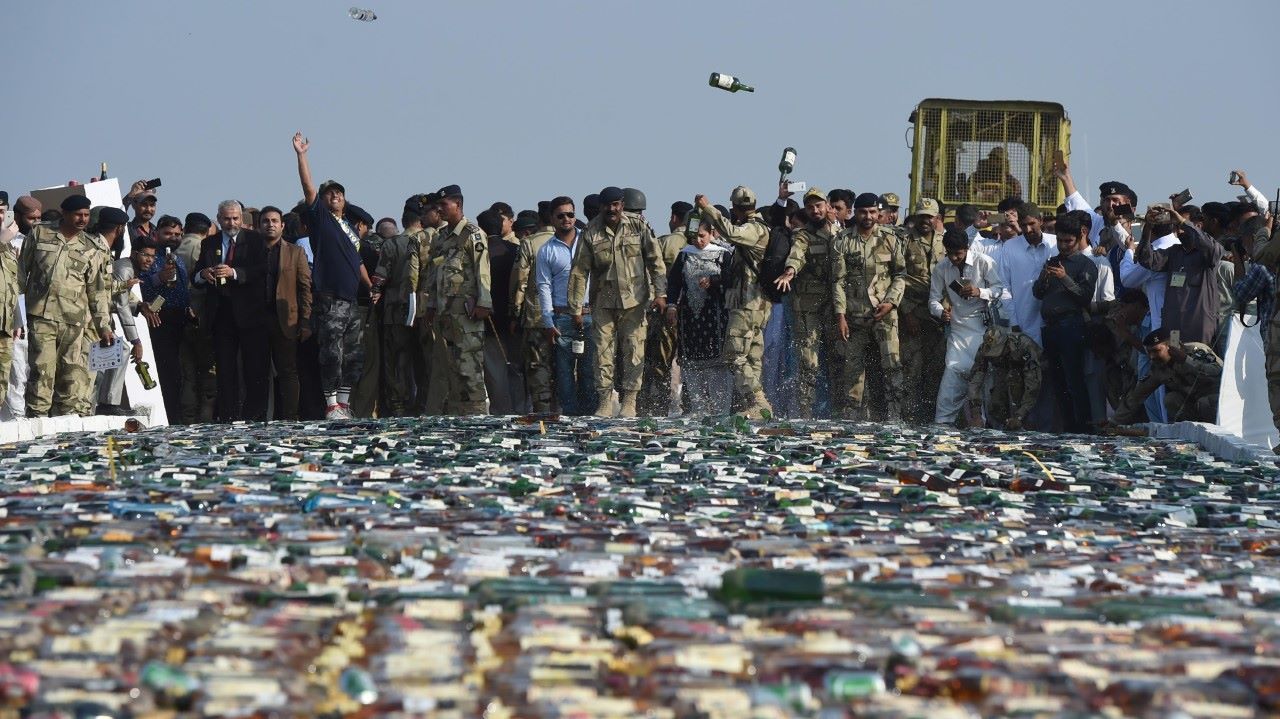 PROHIBIDO. Una apisonadora conducida por guardias costeros destruye botellas de licor el lunes 13 de noviembre de 2017, en Karachi, Pakistán. Los guardacostas paquistaníes destruyeron una gran cantidad de licor ilegal y drogas que han sido...